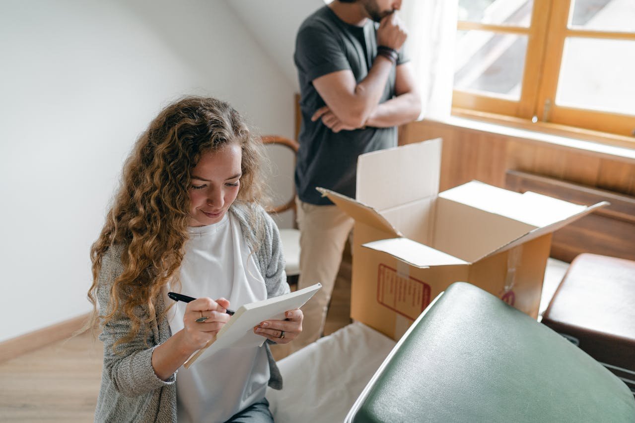 A couple is creating the ultimate moving checklist while packing belongings.