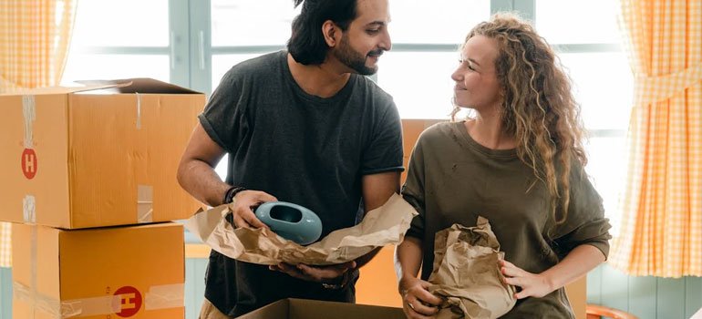 a couple packing talking about how to downsize your belongings for a move