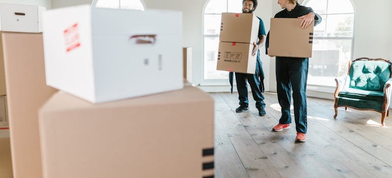 two movers taking out the boxes, ilustrating how to downsize your belongings for a move