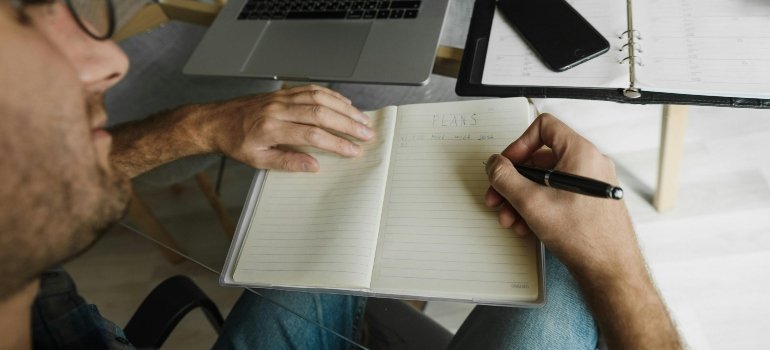 Man Making Notes in Notebook