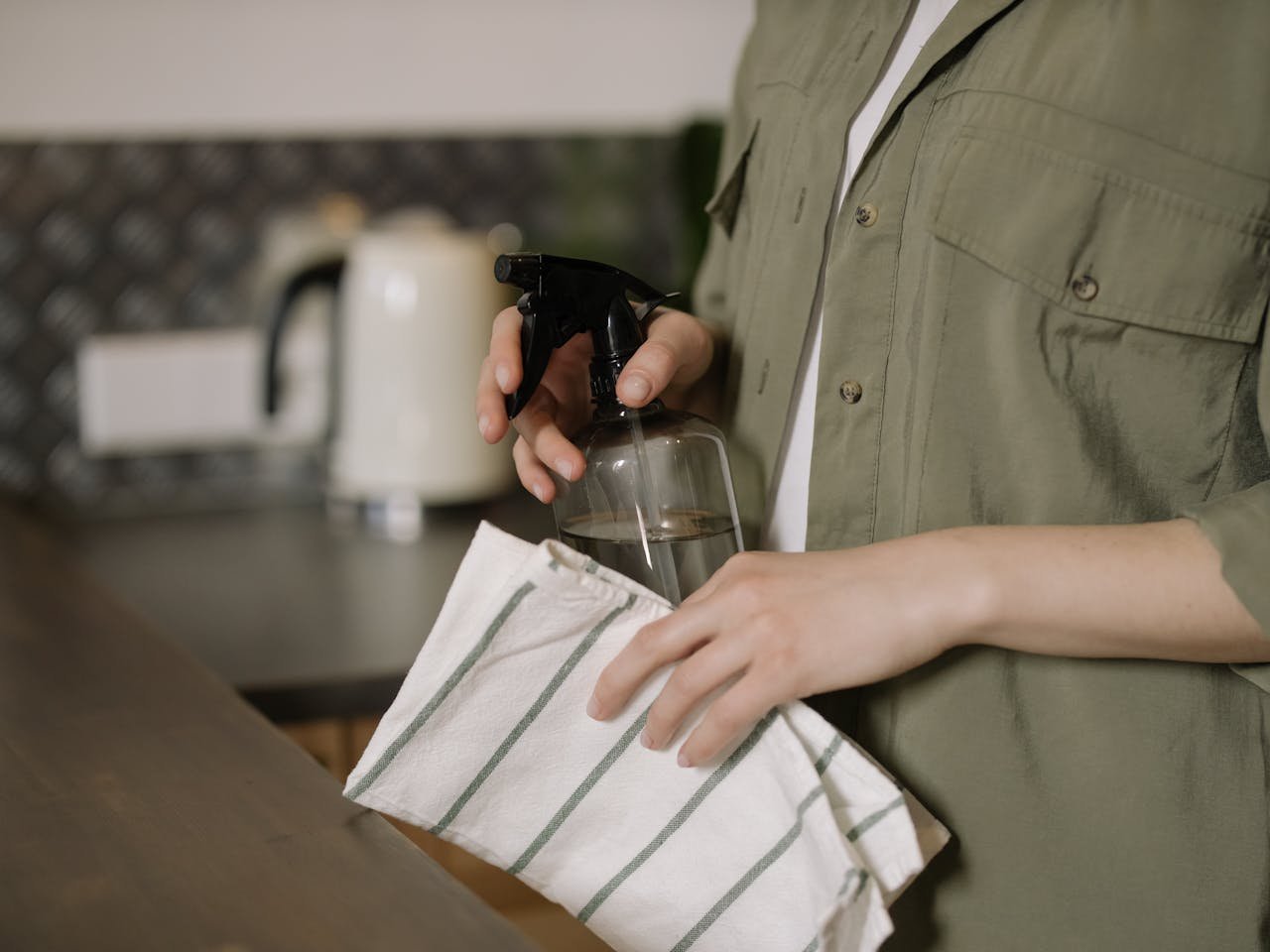 A person holds a spray bottle asking how to clean an apartment before moving out