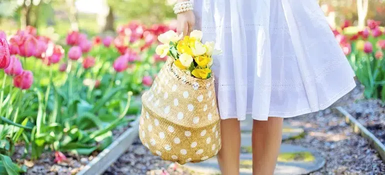 Best getaways in Ohio for every season 2 a woman in a white dress surrounded by flowers during spring weekend vacations in Ohio