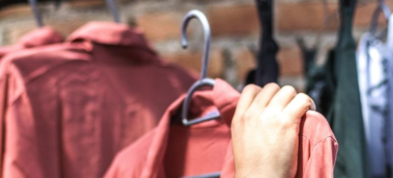 Person preparing a wardrobe using the best way to pack clothes for moving