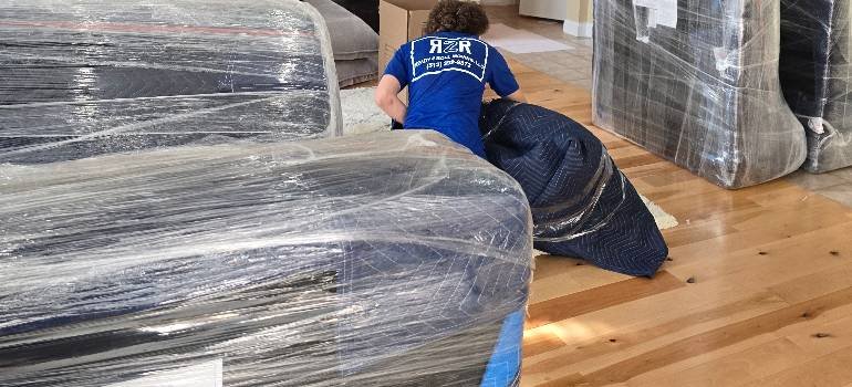 A comprehensive guide for families moving to Hamilton OH 6 movers packing items with the help of a professional relocation guide to Hamilton Ohio