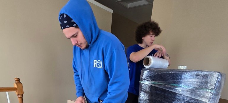 two workers from a Cincinnati Ohio safe moving company packing a large shipment