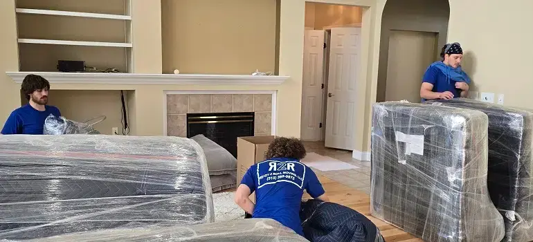 3 incredible ways to save money when moving 2 Moving crew wrapping furniture with protective plastic