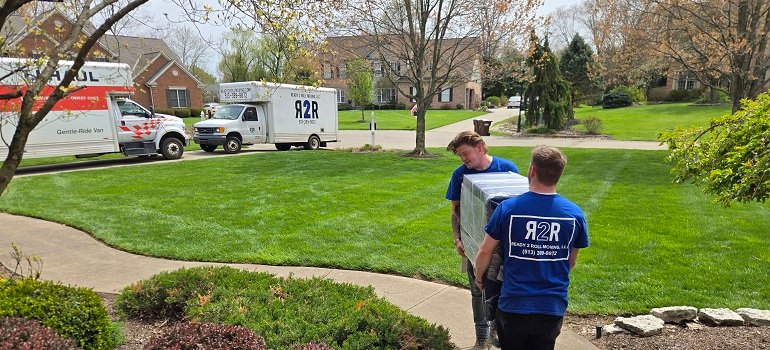 Sharonville movers carrying a large moving box