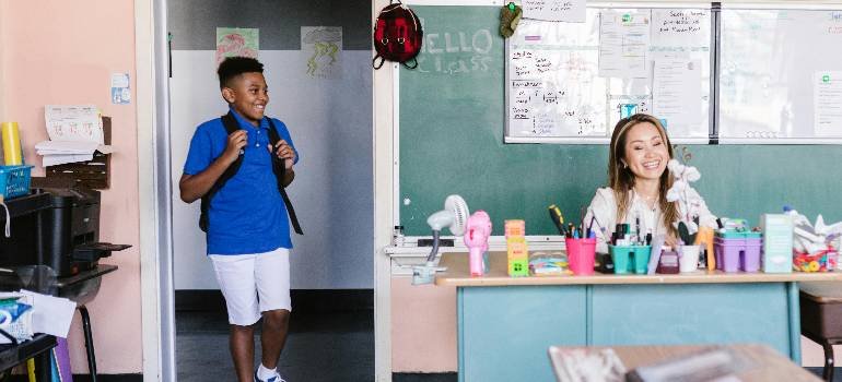 Student arriving late smiling at friendly teacher