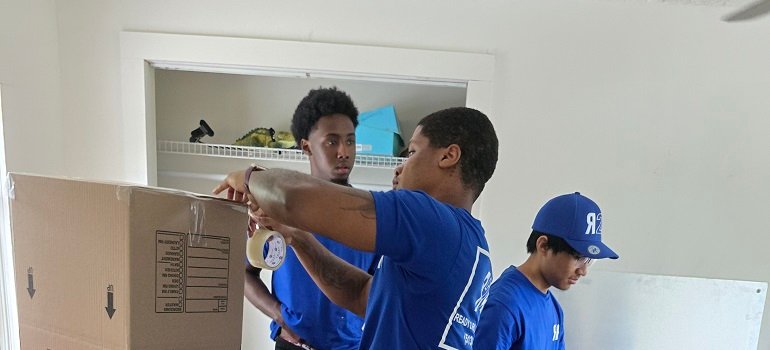 Essential steps to take before moving into your new Milford apartment 3 Movers packing boxes while moving into your new Milford apartment