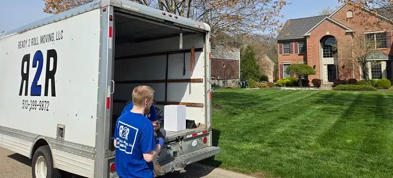 Mover unloading items from truck in suburban neighborhood