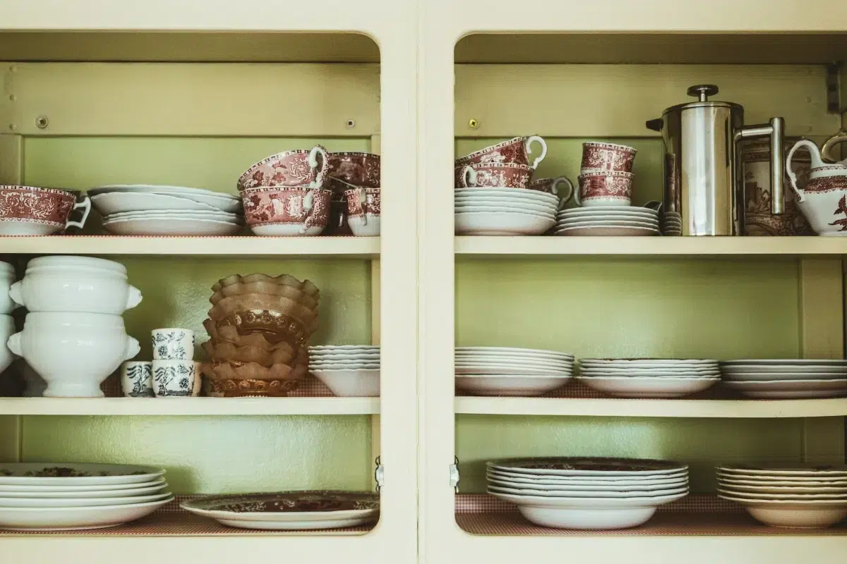 A cabinet with dishes and plates posing the question on how to pack china for moving