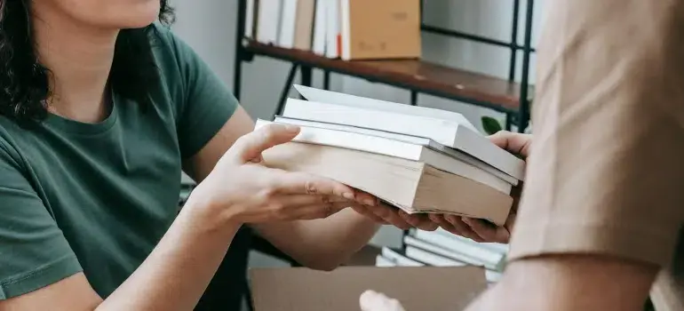 The best way to pack books for moving 4 Couple sorting books to keep, sell, or donate