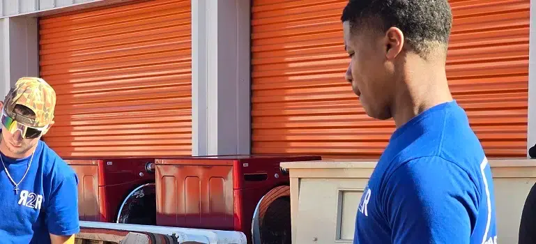 two professional movers loading a moving van.
