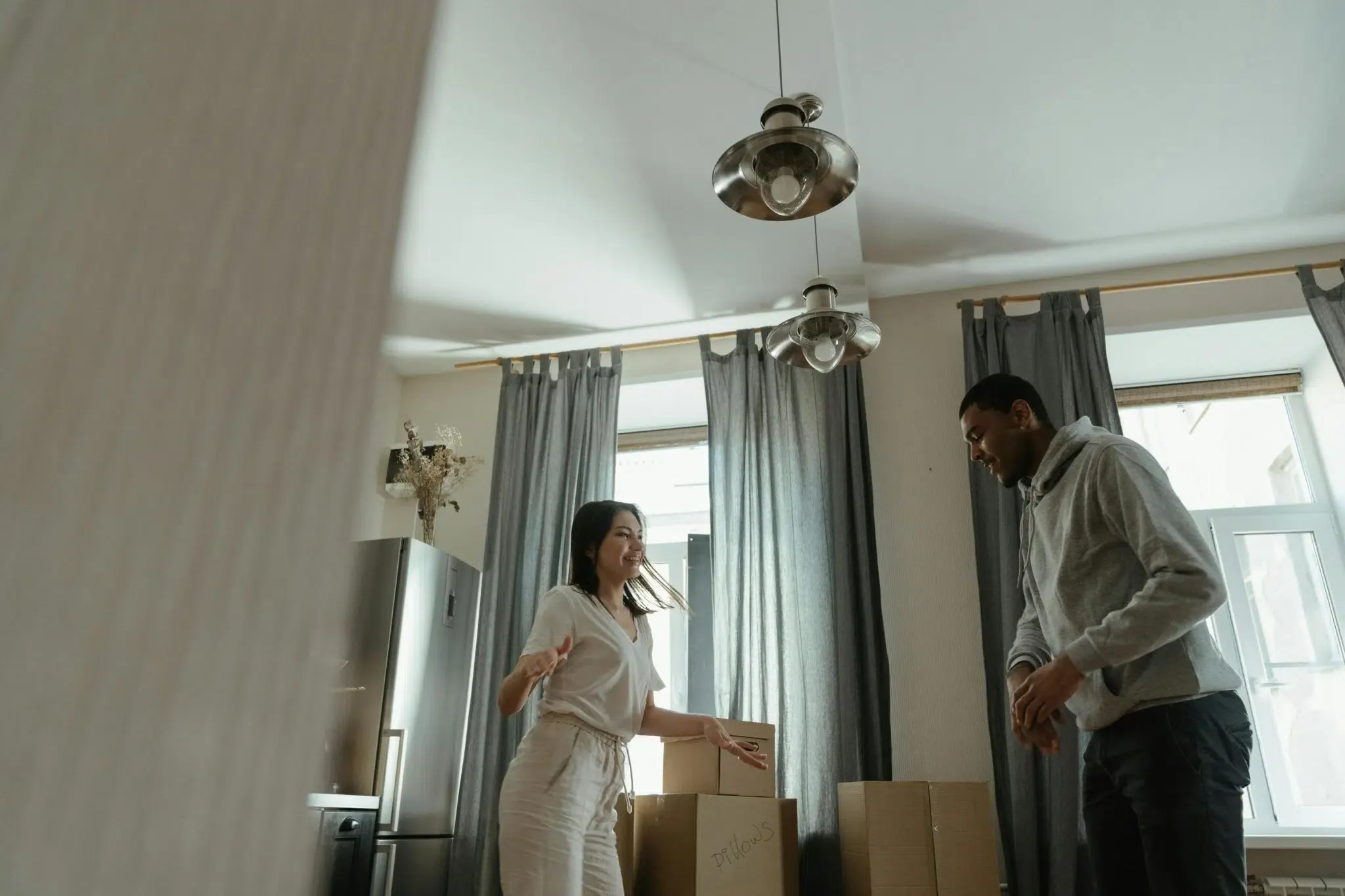 Couple smiling and looking around in their new apartment