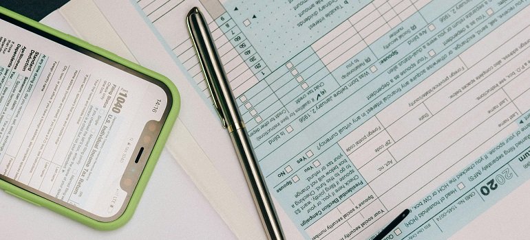 Essential paperwork you cannot ignore after moving to West Chester OH from out of state 2 Tax forms and phone beside a pen