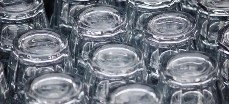 How To Pack Glassware For Moving 3 A neatly arranged collection of clear glass cups turned upside down, tips on how to pack glassware for moving