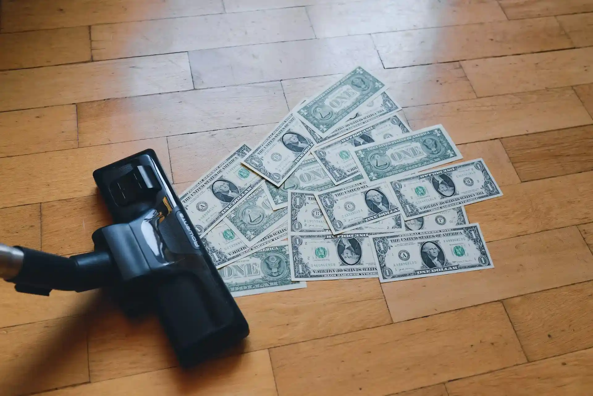 Vacuum cleaner next to dollar bills on the floor