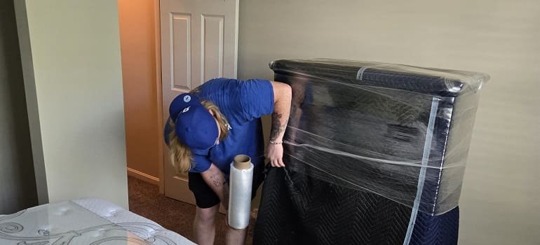 Movers wrapping sofa