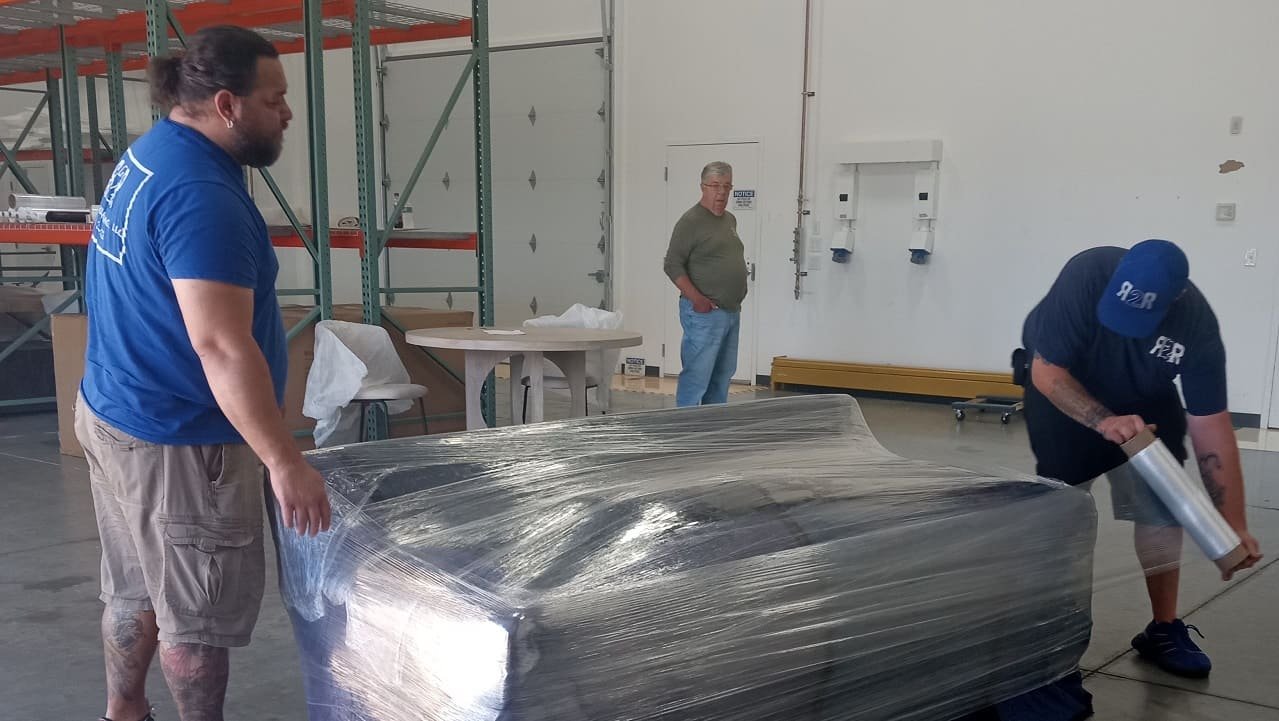 Movers wrapping mattress because packing materials are worth buying